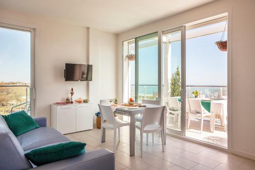 salon ze stołem i krzesłami oraz balkonem w obiekcie Residence Sunrise w Cesenatico