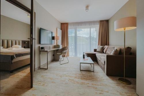 a hotel room with a bed and a couch at Five Seasons Szklarska Poręba in Szklarska Poręba