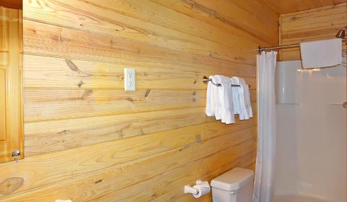 a bathroom with a wooden wall with a shower at Wimberley Log Cabins Resort and Suites- Unit 8 in Wimberley
