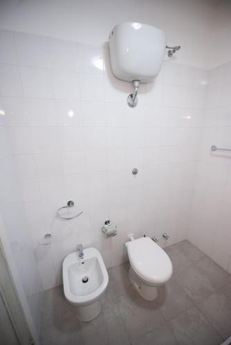 a white bathroom with a toilet and a bidet at Villa Moschella in Taormina