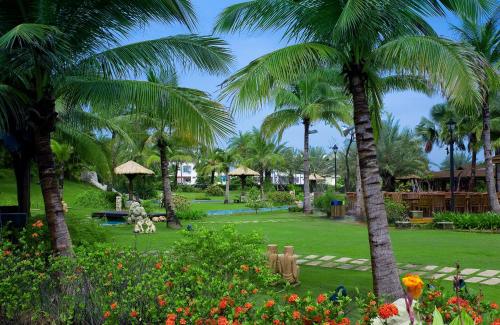 a park with palm trees and flowers at Queena Plaza Hotel in Yongkang