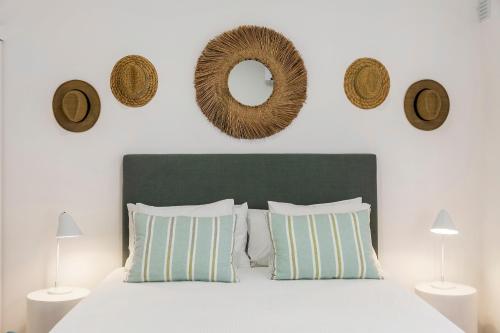 um quarto com uma cama com almofadas e um espelho em RG Studio em Faro