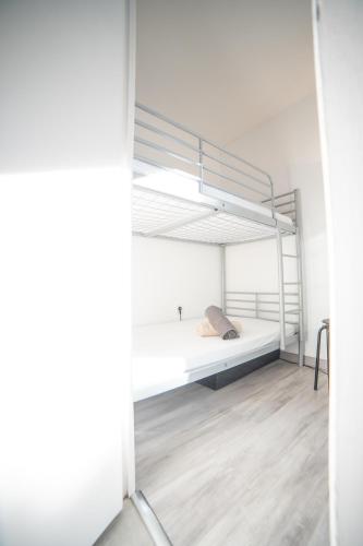 - une chambre blanche avec des lits superposés dans l'établissement CORAIL STUDIO - 2MIN PLAGE CENTRE VILLE - CLIM - WIFI - PARKING PRIVÉ - IDEAL FAMILLE - La Grande Motte, à La Grande Motte