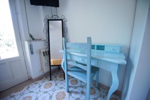 a blue desk with a chair next to a mirror at Villa Moschella in Taormina