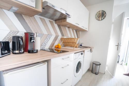 une cuisine avec un lave-linge et un sèche-linge sur un comptoir dans l'établissement CORAIL STUDIO - 2MIN PLAGE CENTRE VILLE - CLIM - WIFI - PARKING PRIVÉ - IDEAL FAMILLE - La Grande Motte, à La Grande Motte