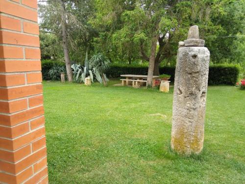 a stone monument in the grass next to a brick building at Agriturismo Le Chicche di Mafalda in Montemerano