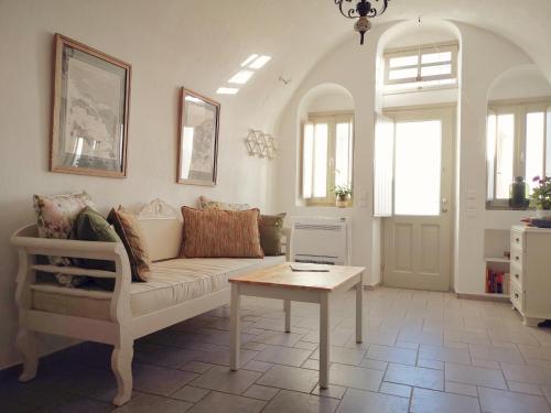 a living room with a couch and a table with a laptop at Spitia Tzitzi in Imerovigli
