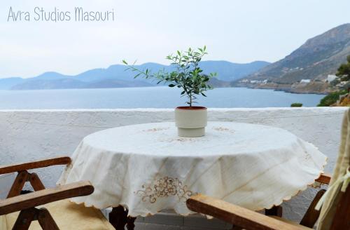a table with a white table cloth and a plant on it at Avra Studios in Masouri