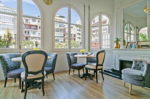 a room with chairs and a table and a fireplace at Mihlton Barcelona Boutique B&B in Barcelona