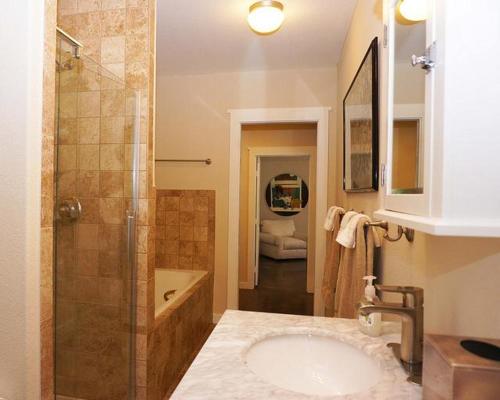 a bathroom with a shower and a sink and a tub at Deer Run- Creekhouse in Wimberley