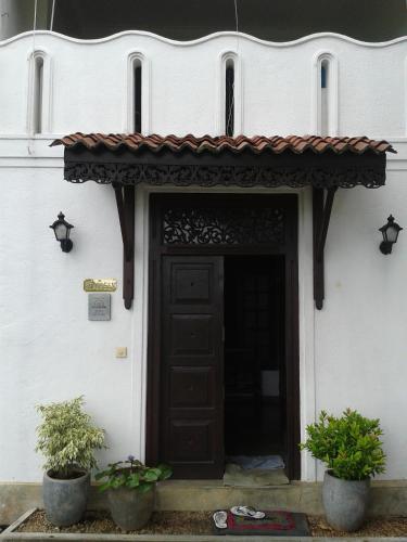 an entrance to a white building with a brown door at Seagreen Guesthouse - Galle Fort in Galle