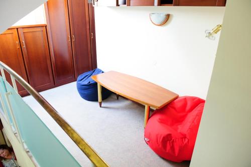 Zimmer mit einem Holztisch und einem roten Stuhl in der Unterkunft Apartments SOELEK - Vila Golf in Rogaška Slatina