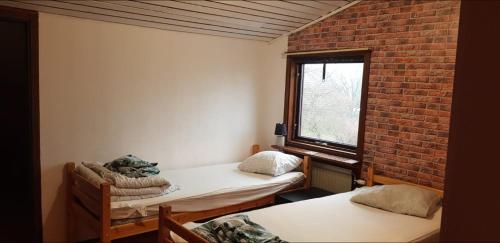 a room with two beds and a brick wall at Fint parhus in Falkenberg