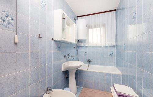 a blue tiled bathroom with a sink and a toilet at Apartments Vesna in Pinezici