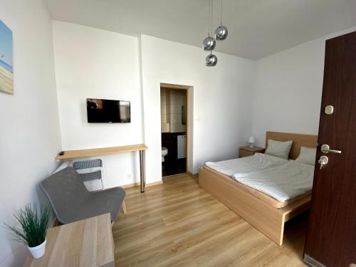 1 dormitorio pequeño con 1 cama y 1 silla en Zefir Pokoje, en Unieście
