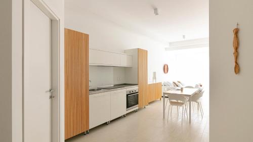 una cocina con armarios blancos y una mesa con sillas. en Rivazzurra Homes - C en Termoli