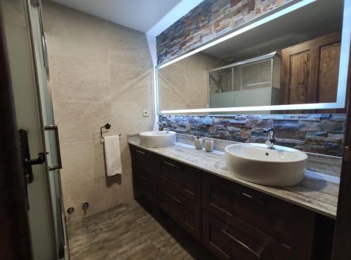 a bathroom with two sinks and a mirror at LAS 4 ESTACIONES - Rascafría in Rascafría