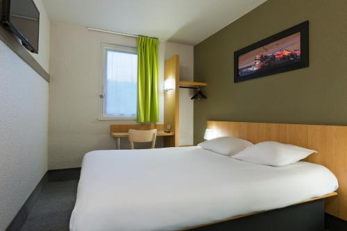 Tempat tidur dalam kamar di Enzo Hotels Nancy Frouard by Kyriad Direct