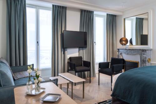 a bedroom with a bed and a living room at Hotel Louvre Montana in Paris