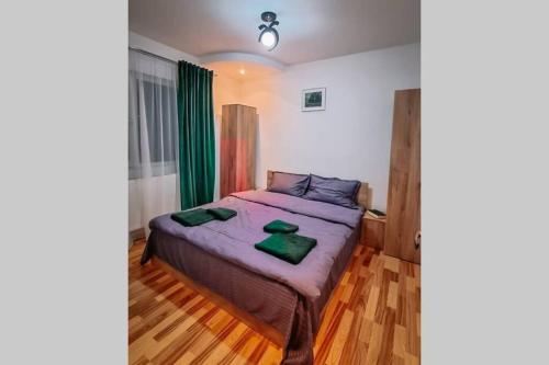 una camera da letto con un letto e asciugamani verdi di Cervo Mountain House a Nehoiu