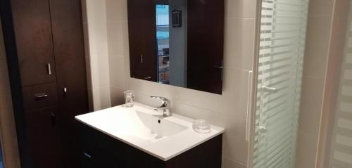 une salle de bain avec un lavabo et un miroir dans l'établissement Appartement pour 4, plage des 5 Pineaux, à Saint-Hilaire-de-Riez