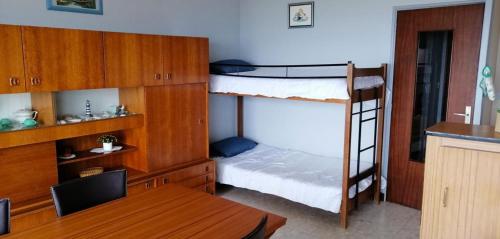 - une chambre avec 2 lits superposés, un bureau et une table dans l'établissement Appartement pour 4, plage des 5 Pineaux, à Saint-Hilaire-de-Riez