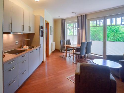 eine Küche und ein Esszimmer mit einem Tisch und Stühlen in der Unterkunft Dünenpark Binz - Komfortplus Ferienwohnung mit 1 Schlafzimmer und Terrasse im Erdgeschoss 164 in Binz