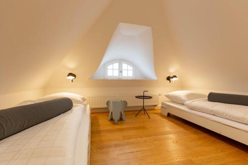 a attic room with two beds and a window at Pur A4 in Wustrow