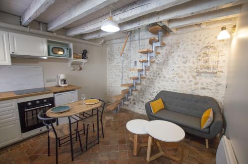 a living room with a couch and a table and chairs at Le logis des Remparts, au coeur de Sancerre in Sancerre