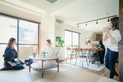 a woman taking a picture of people in a room at Kumamoto - Apartment / Vacation STAY 81139 in Kumamoto