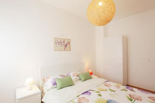 Dormitorio blanco con cama y lámpara en Apartment Maria, en Medulin