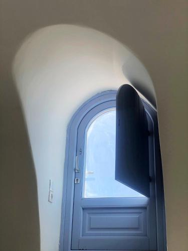 a blue door with a window in a room at Thera Incognita Studios in Perissa