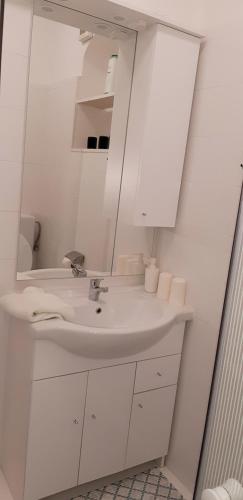 a white bathroom with a sink and a mirror at Apartma Sonja 2 piran in Piran