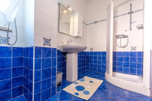a blue tiled bathroom with a sink and a shower at Residence Palazzo Sayonara in Tortoreto Lido