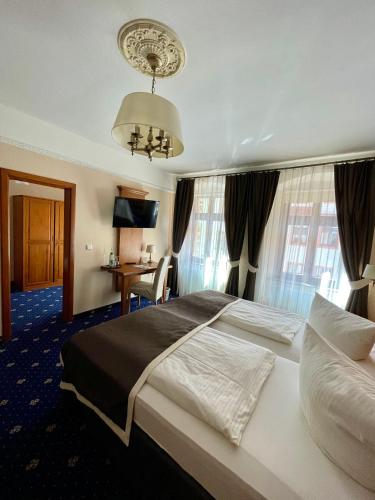 a hotel room with a large bed and a desk at Hotel Italia in Görlitz