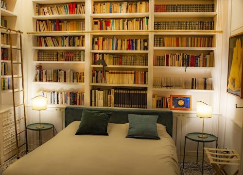 ナポリにあるla stanza del filosofoのベッドルーム1室(ランプ2つ、本棚付)