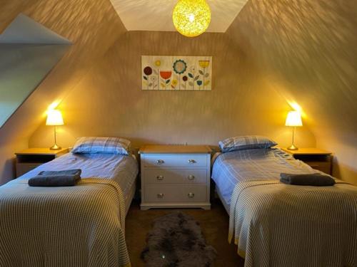 2 camas num quarto no sótão com 2 candeeiros em Burnside & Jocks Cottage on the Blarich Estate em Rogart