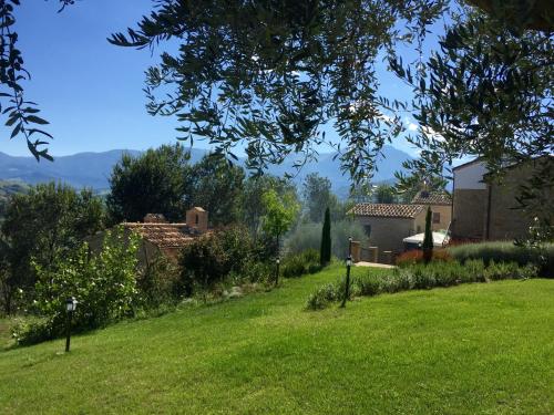 a yard with a green lawn with houses and trees at agriturismo borgo del ginepro in Castiglione Messer Raimondo