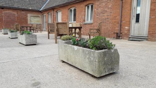 a group of concrete planters with plants in them at Courtbrook Farm Apartments in Exeter