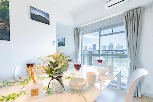 ein Esszimmer mit einem Tisch und Gläsern Wein in der Unterkunft Feel Asakusa Stay in Tokio