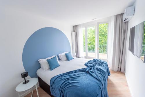 a bedroom with a large bed with a blue headboard at Opera in Paris