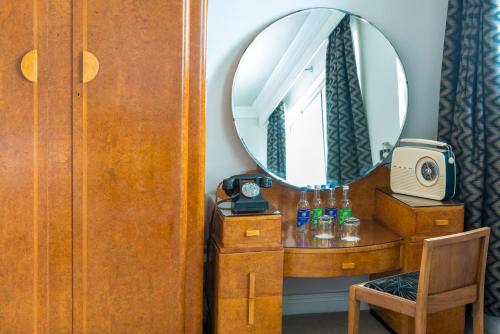 a dressing room with a mirror and a dressing table at Burgh Island Hotel in Bigbury on Sea