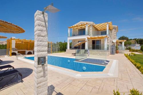 a villa with a swimming pool in front of a house at Villa Zeas in Halikounas