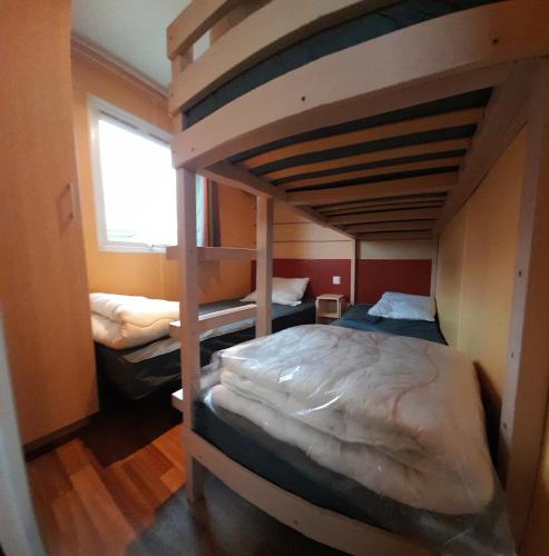 une chambre avec deux lits superposés et une fenêtre dans l'établissement Mobil home climatisé 5 pers 11210 port la nouvelle, à Port-la-Nouvelle
