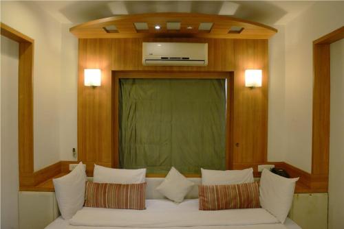 ein Wohnzimmer mit einer weißen Couch mit Kissen in der Unterkunft Beautiful Hotel In Lonavala in Lonavla