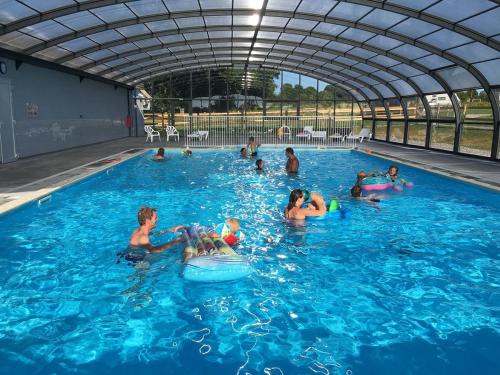 un groupe de personnes jouant dans une piscine dans l'établissement Safaritent Glamping Normandie, à Longueville