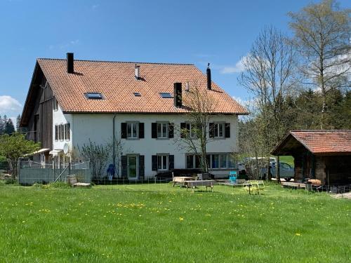 a large white house with a yard with benches at Vent_du_Nord in Tramelan