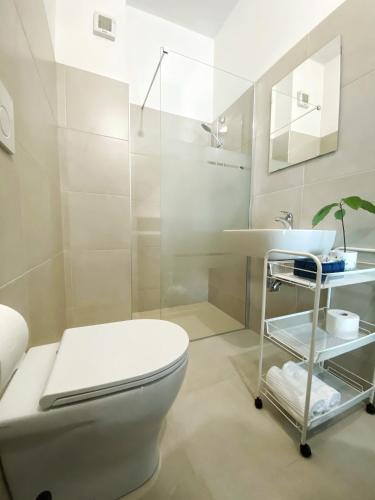 a bathroom with a white toilet and a sink at Hotel Dinarica in Marotta
