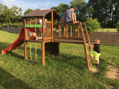 un homme et un garçon jouant sur une aire de jeux dans l'établissement Safaritent Glamping Normandie, à Longueville