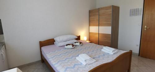 a small bedroom with a bed with towels and a cabinet at Apartmani Mila-Casa Bianca in Medulin